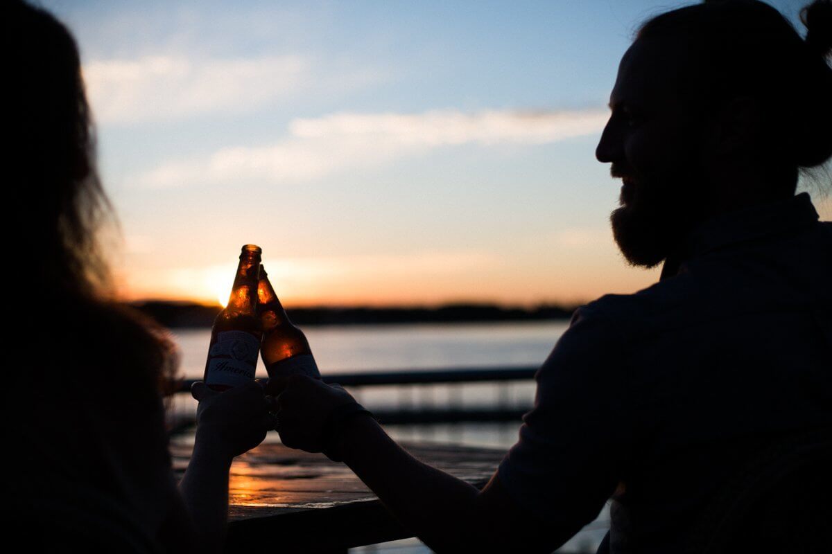 silhoutte of man and woman holding beer