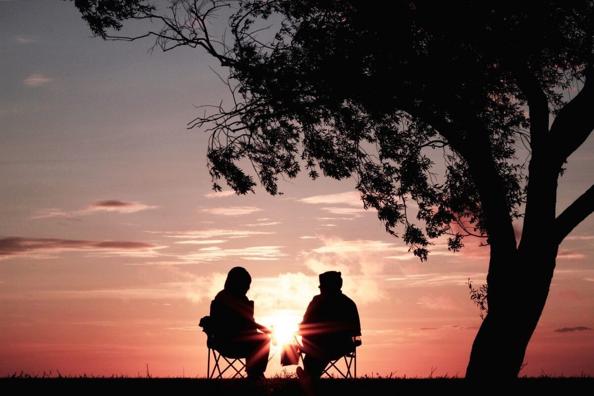 silhoute of two person sitting on chair